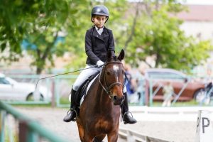 Junge Reiterin mit ausgebildetem Dressurpferd